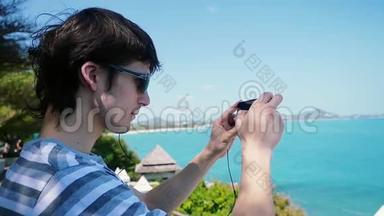 戴太阳镜的年轻人在海滩上用他的智能手机拍照。 苏梅岛。 泰国。 <strong>1920</strong>x1080